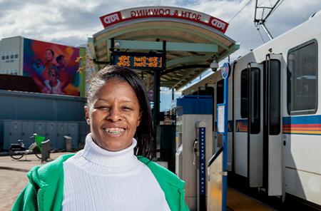 Tasha Clavo stands in front of the L Line 30th and Downing stop